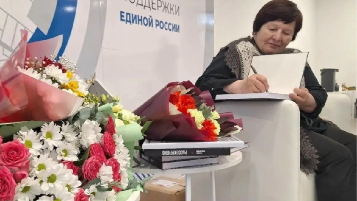 Писательница подписывает книгу