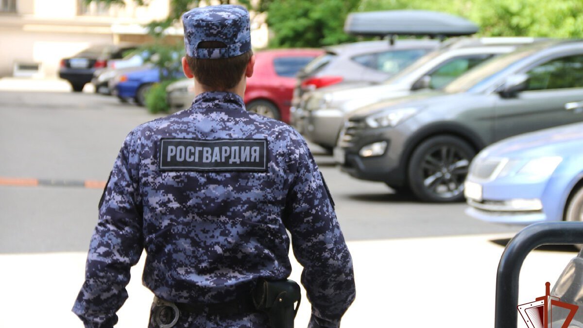 Росгвардеец в форме идет по улице летом.