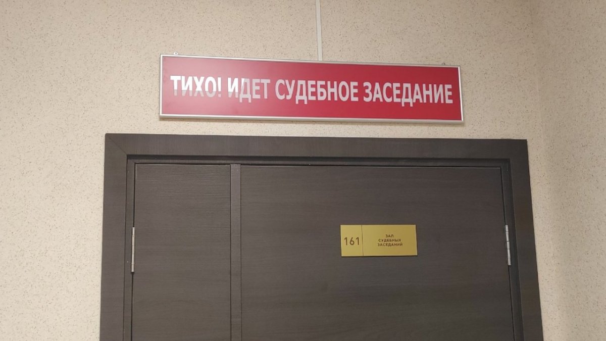 Зал судебного заседания с табличкой.