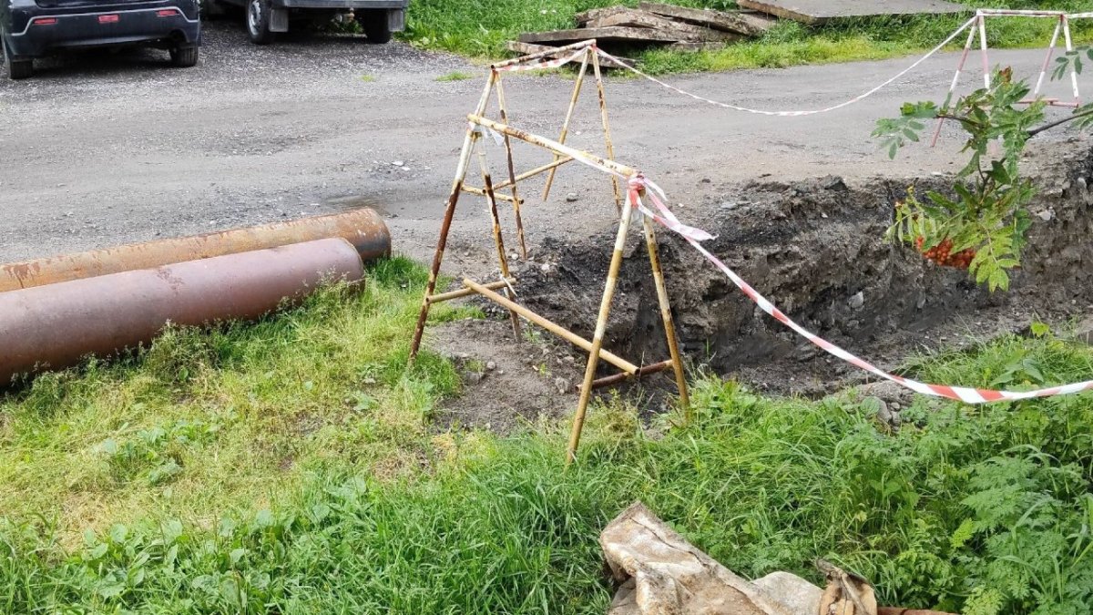 Чугунные трубы теплоснабжения валяются на земле возле дороги летом.