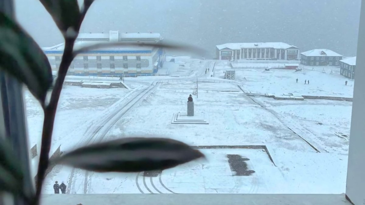 Вид из окна дома на заснеженную площадь.