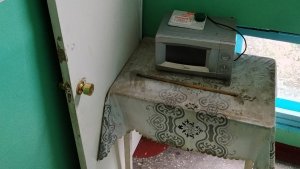 Дверь, старая микроволновка и стол — на лестничной площадке в Молочном устроили «филиал» кухни