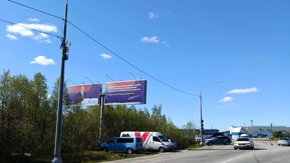 Камера видеофиксации висит на столбе возле дороги.