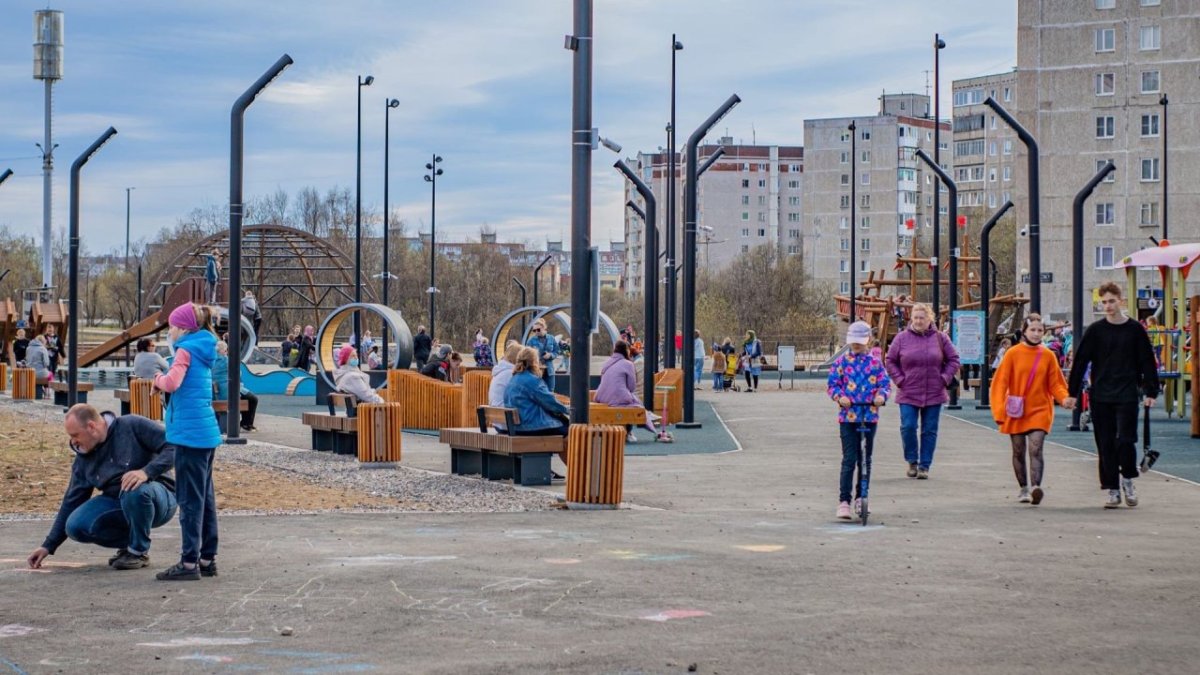 Взрослые и дети ходят в парке осенью.