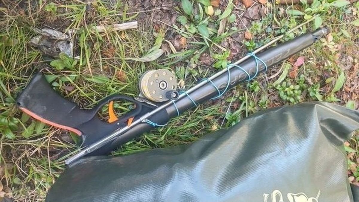 Подводное ружье лежит на траве осенью.