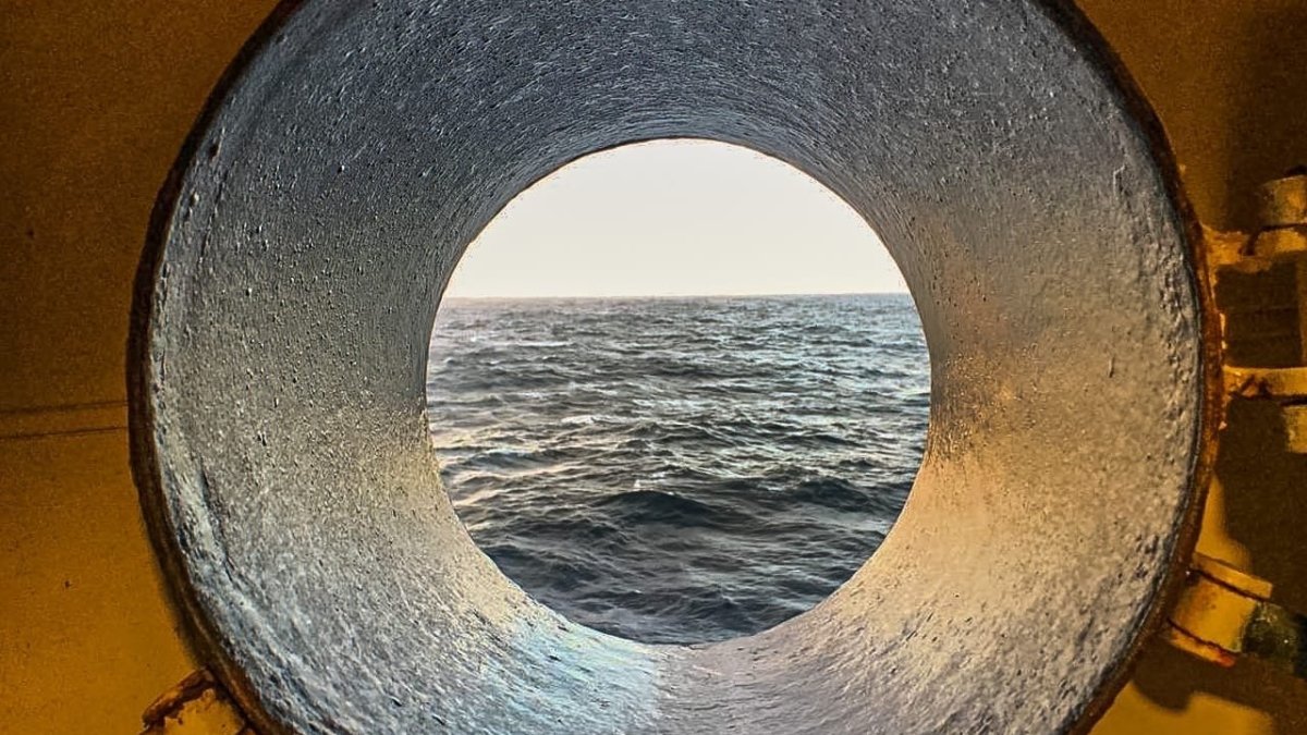 Море виднеется из иллюминатора судна.
