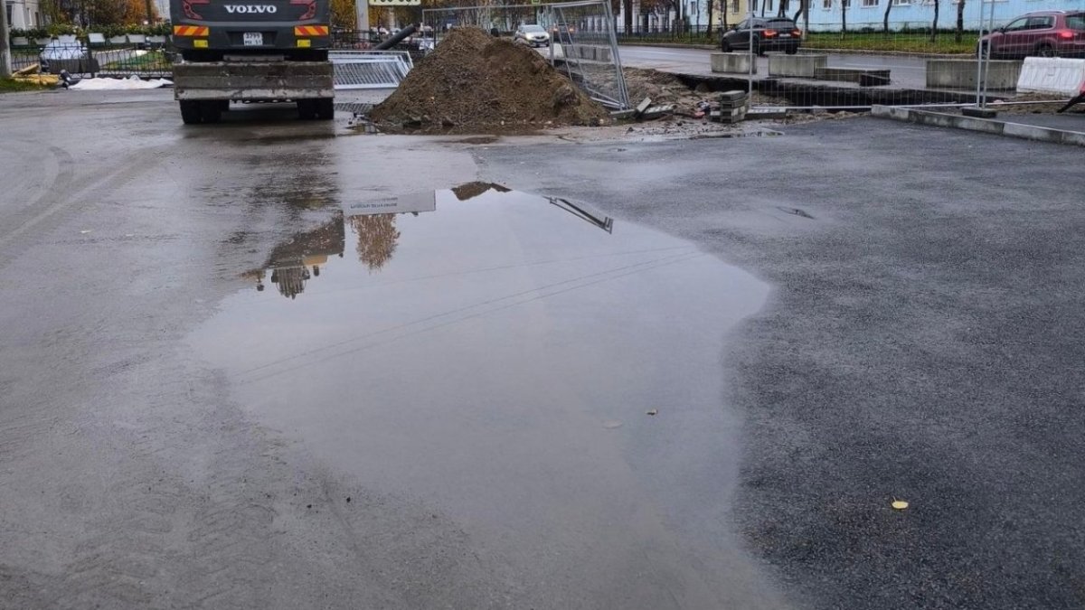 Лужа на асфальте осенью в городе.