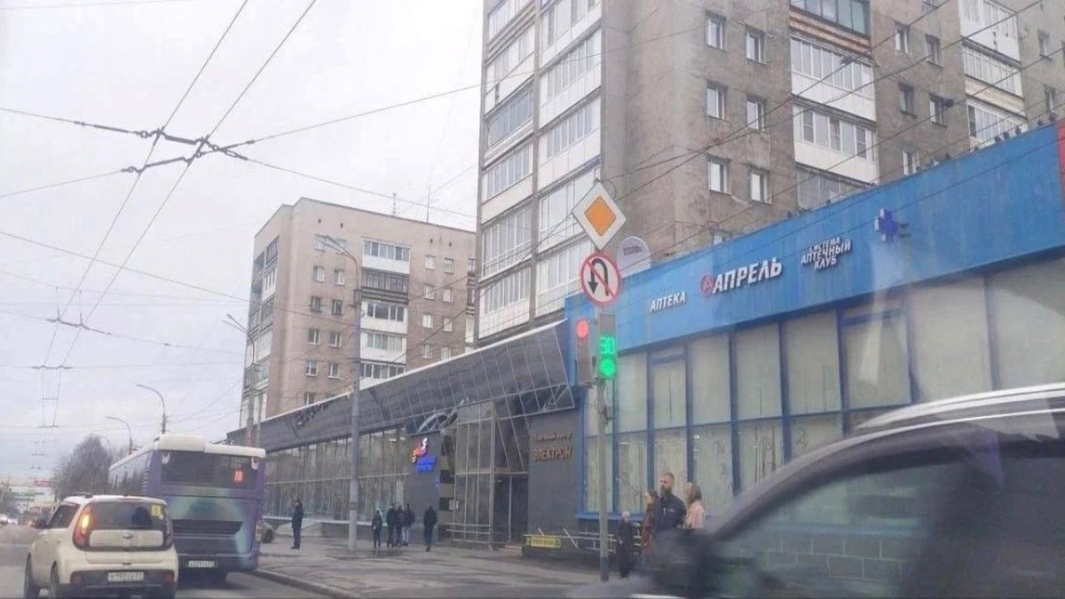 Знак "Разворот запрещен" на фоне дороги в городе осенью.