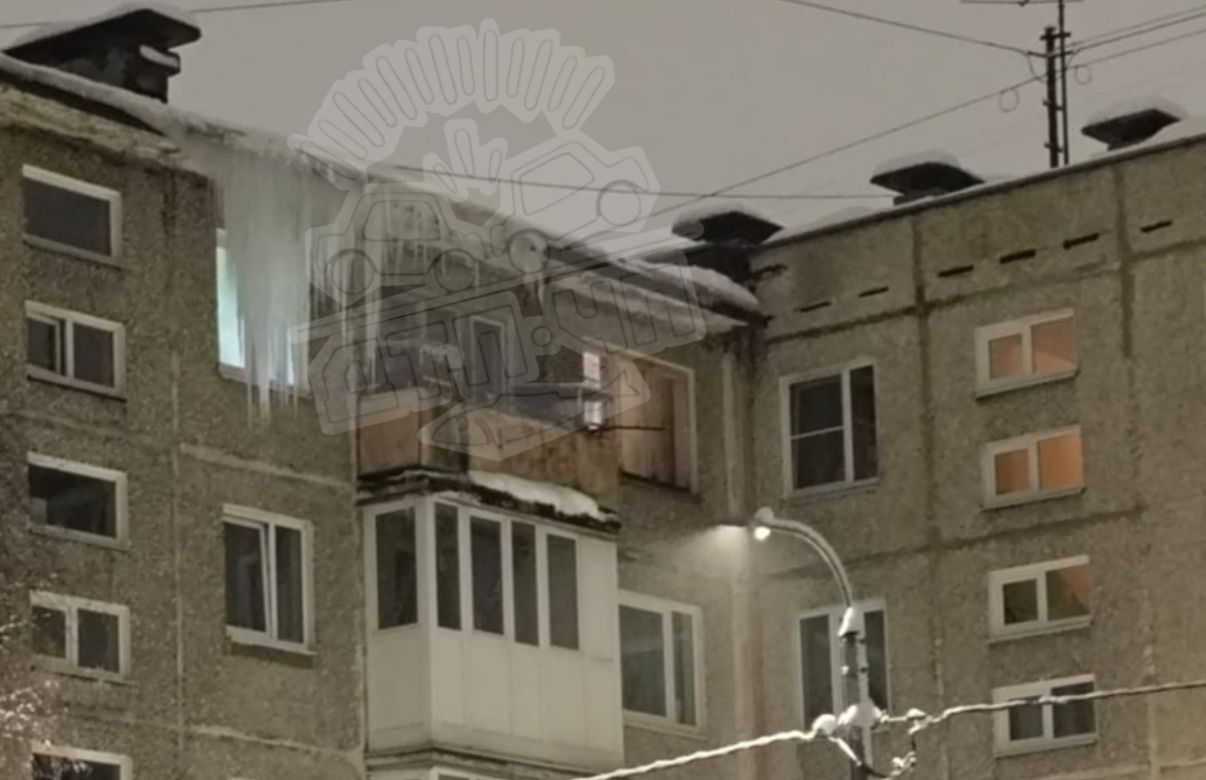 В Мурманске свисающая с крыши дома глыба льда заслонила окно и целится в прохожих
