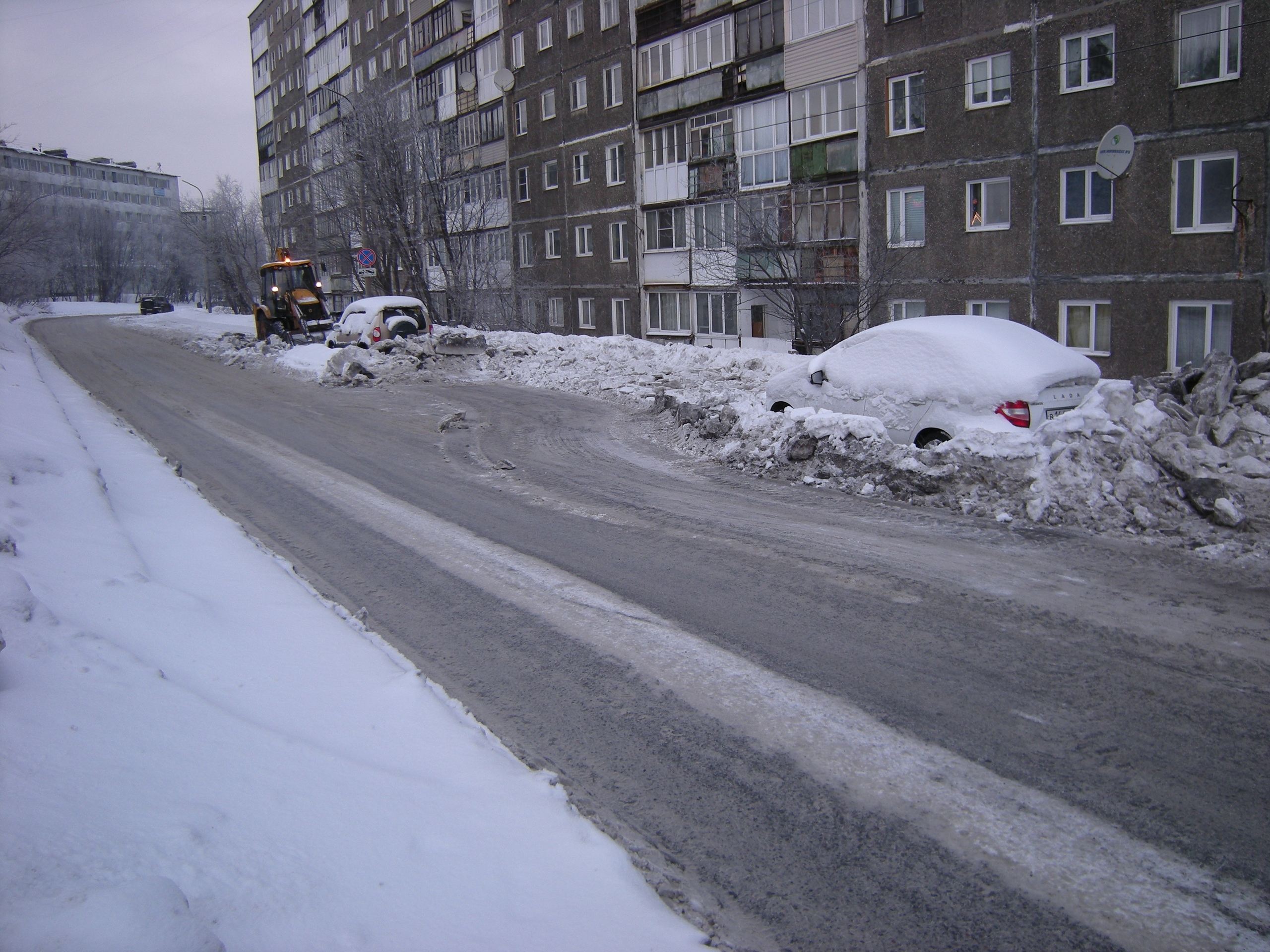 «Скорее всего, там два Эвереста»: в Мурманске при уборке снега трактор закопал брошенные на дороге авто