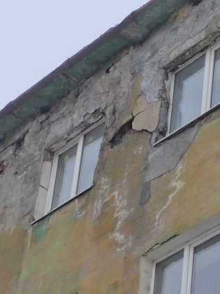 Куски кирпичей и льда падают с крыши дома в центре Мурманска