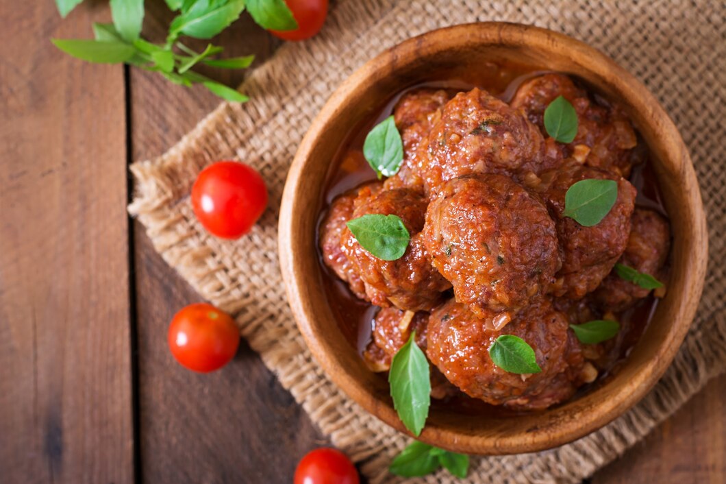 <p><img src="https://novosti-murmanskoy-oblasti.ru/uploads/posts/2025-02/1739806395_meatballs-sweet-sour-tomato-sauce-basil-wooden-bowl_2829-7660.jpg" alt="" /></p>

<p><em>Ежики запекают в томатном соусе</em></p>
<p><br />Этот рецепт на канале &laquo;Едим дома&raquo; из старого кулинарного журнала &laquo;Еда&raquo; за 2008 год. Рецепт отличается тем, что изделия ставят в духовке без соуса, его заливают, как только мясо подрумянится. Такие ежики подают с любым гарниром, вкусно с тушеной квашеной капустой и овощным салатом. Ингредиенты:</p>
<p><br />&bull; мясной фарш &mdash; 700 г<br />&bull; рис круглозерный &mdash; 0,5стакан<br />&bull; лук репчатый &mdash; 1 шт.<br />&bull; чеснок &mdash; 2 зубчик<br />&bull; хмели-сунели &mdash; по вкусу<br />&bull; сметана &mdash; 250 г<br />&bull; томатная паста &mdash; 2 ст. л.<br />&bull; сахар &mdash; 1 ч. л.<br />&bull; соль &mdash; по вкусу<br />&bull; перец черный молотый &mdash; по вкусу<br />&bull; растительное масло для жарки &mdash; 2 ст. л.</p>
<p><br />Смешиваем фарш с отваренным рисом, измельченным луком и чесноком, добавляем холодной воды, перчим, солим, добавляем хмели-сунели. Тщательно вымешиваем и отбиваем. Из фарша формируем ежики, обваливаем их в муке, и отправляем в разогретую духовку.</p>
<p><br />Пока ежики в духовке, готовим соус. В сковороде соединяем томатную пасту и сахар, Остужаем немного, добавляем сметану, перемешиваем, солим и перчим по вкусу. Добавляем немного воды.</p>

<p>Как только на ежиках в духовке образуется корочка, заливаем их подготовленным соусом и готовим под фольгой еще 40 минут.</p>

<p>Ранее мы <a href="https://novosti-murmanskoy-oblasti.ru/46111-tefteli-teper-gotovlyu-tolko-vduhovke-nerazvalivayutsya-poluchayutsya-sochnymi-idazhe-yayca-nenuzhny.html">рассказывали</a>, как приготовить тефтели без добавления яиц. </p>

<p><em>Айгуль Булатова</em></p>
<p><em>Фото: Freepik</em></p>


