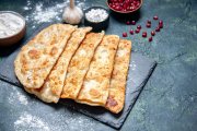 <p><img src="https://novosti-murmanskoy-oblasti.ru/uploads/posts/2024-12/1733168449_front-view-tasty-gutabs-thin-delicious-hotcakes-with-meat-dark-surface_179666-44185.jpg" alt="" /></p>

<p><em>Эти лепешки с мясом получаются такими, что пальчики оближешь!</em></p>

<p>Сегодня хочу поделиться рецептом китайских лепешек с мясом. Рецепт очень простой и очень вкусный! Лепешки получаются сочные, мясистые!</p>

<p>Ингредиенты:<br />Тесто:<br />Мука &mdash; 400-450 гр.<br />Соль &mdash; &frac12;ч.л.<br />Вода &mdash; 250 мл<br />Начинка:<br />Фарш &mdash; 800 гр.<br />Луковица &mdash; 1 шт.<br />Чеснок &mdash; 3 зуб.<br />Соль &mdash; &frac12;ч.л.<br />Приправа для курицы &mdash; 1/3 ч. л.<br />Зелень &mdash; по вкусу.</p>

<p>В глубокую миску кладем 400 г муки, делаем углубление в центре, наливаем теплую воду, добавляем соль и замешиваем тесто. Отправляем тесто в пакет и ставим отдохнуть.</p>

<p>Для начинки в фарш добавляем измельченный лук и чеснок, соль, зелень, приправу и хорошо перемешиваем.</p>

<p>Тесто делим на 8 частей, каждую часть раскатываем в круг диаметром 20-25 см. И визуально круг разделим на 4 части. На 3 части ровным тонким слоем распределяем фарш. Делаем разрез от центра к краю.</p>

<p>Накрываем третью часть фарша, закрепляем края. Затем накрываем следующую часть фарша, закрепляем края, получилась половинка круга. После этого накрываем оставшуюся часть с фаршем, получается &frac14; часть круга, закрепляем края. Так делаем со всеми лепешками.</p>

<p>Лепешки жарим на сухой сковороде, на слабом огне под крышкой, по 3-5 минут с каждой стороны. Готовые лепешки смазываем с двух сторон растопленным сливочным маслом.</p>


<p><em>Ольга Артасова</em></p>
<p><em>Фото: freepik</em></p>