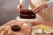 <p><img src="https://novosti-murmanskoy-oblasti.ru/uploads/posts/2025-01/1736491377_close-up-hands-preparing-cake_23-2149144136.jpg" alt="" /></p>

<p><em>Коржи для этого торта выпекают в сковороде под крышкой</em></p>
<p><br />Этот рецепт станет спасением для тех, у кого не духовки. Выпеченные в сковороде коржи обладают такой же мягкой и воздушной консистенцией. Единственное, нужен миксер, так как крем необходимо хорошенько взбить из-за наличия молочных продуктов. Ингредиенты:</p>
<p><br />Тесто<br />&bull; 2 яйца<br />&bull; &frac34; стакана сахара<br />&bull; &frac14; ч. ложки соли<br />&bull; 3 ст. ложки растительного масла<br />&bull; 1 стакан (250 мл) кефира<br />&bull; 1 ч. ложка соды<br />&bull; 1 стакан пшеничной муки<br />&bull; 3 ст. ложки какао</p>
<p><br />Крем<br />&bull; 1 стакан мягкого творога или сливочного сыра<br />&bull; 1 стакан сметаны или густого натурального йогурта<br />&bull; 4 ст. ложки без верха сахарной пудры<br />&bull; 3 ч. ложки ванильного сахара</p>
<p><br />Глазурь<br />&bull; 3 ст. ложки без верха какао<br />&bull; 4 ст. ложки без верха сахара<br />&bull; &frac12; стакана (3 полные ст. ложки) сметаны или густого натурального йогурта<br />&bull; 2,5 ст. ложки сливочного масла</p>

<p>В чаше миксера соединяем яйца, соль, сахар, растительное масло, кефир и соду, перемешиваем все до однородного состояния на минимальных оборотах. После добавляем просеянную муку и какао. Тесто получается жидким, делим его не три части.</p>
<p><br />Выпекаем коржи на заранее разогретой сковороде. Выпекаем коржи на самом маленьком огне 8-10 минут. Переворачивать коржи не надо. По мере готовности перекладываем корж на решётку, оставляем остывать и сразу выпекаем следующий корж.</p>
<p><br />Для крема в чаше взбиваем творог со сметаной, всыпаем сахарную пудру и ванильный сахар. Готовым кремом смазываем все коржи и убираем заготовку торта в холодильник. Тем временем приступаем к приготовлению глазури.</p>
<p><br />В сотейнике доводим до кипения смесь из сахара, какао, сметаны. Варим массу примерно полминуты, снимаем с огня и в горячую массу добавляем 2,5 ст. ложки сливочного масла. Перемешиваем до однородного состояния и покрываем ею торт.</p>

<p>Ранее мы рассказывали, как приготовить<a href="https://novosti-murmanskoy-oblasti.ru/45725-muraveynik-bez-vypechki-za15-minut-kak-vsego-lish-iztreh-ingredientov-bystro-prigotovit-sladkoe-kchayu-spravitsya-dazhe-rebenok.html"> муравейник</a> без выпечки за 15 минут.</p>

<p><em>Айгуль Булатова</em></p>
<p><em>Фото: Freepik</em></p>

